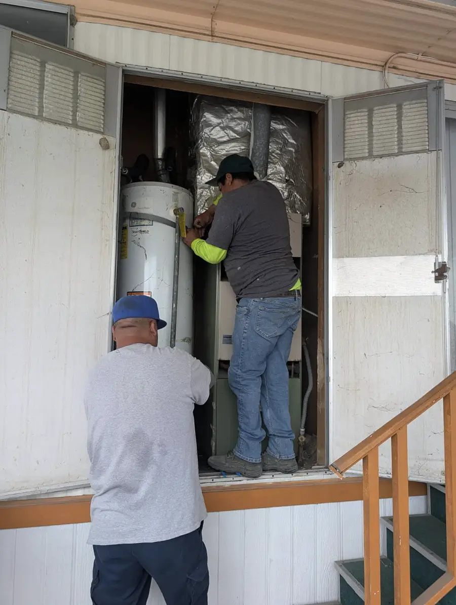 Knockout Plumbing technicians installing residential water heater
